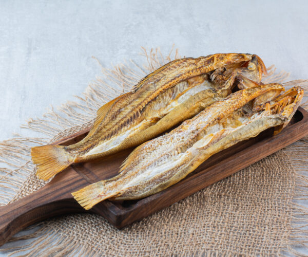 Salty dried fish isolated on a wooden board . High quality photo