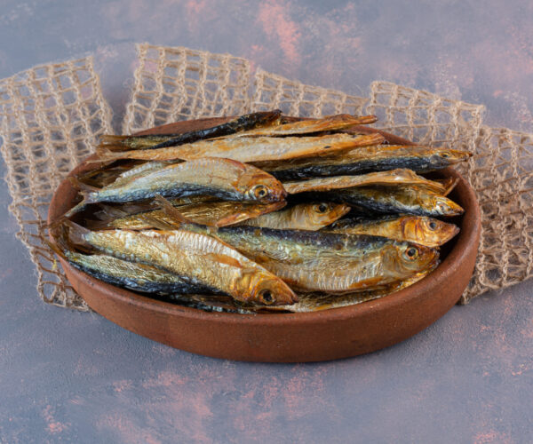 Tasty salted fish on a wooden plate , on the marble background. High quality photo